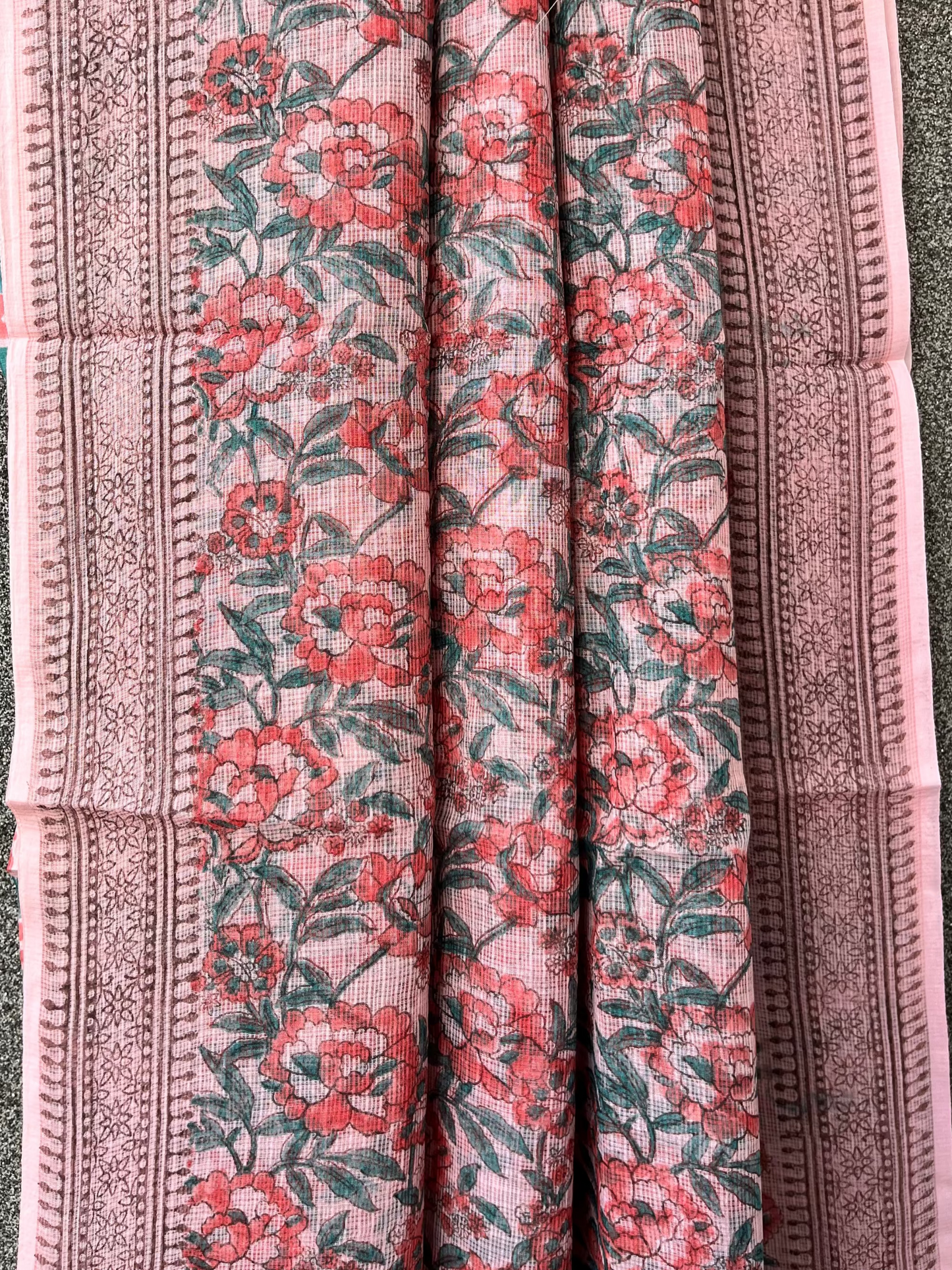 Floral patterned saree with pink and green flower motifs on a textured background